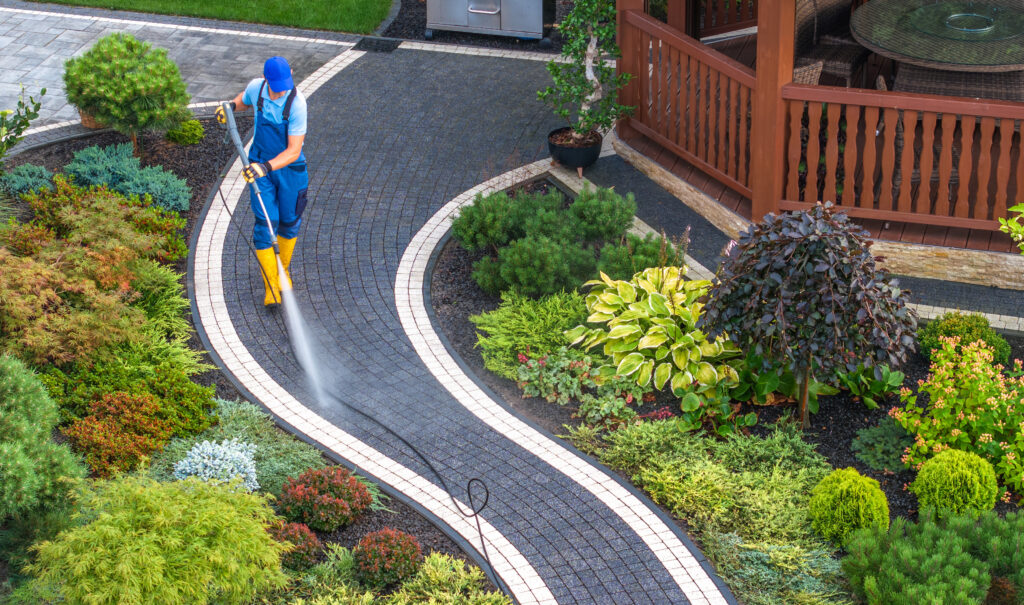 Overhead view of an Eco-steam employee pressure washing a walkway next to a home.